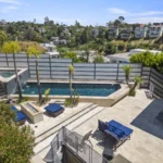 A luxurious backyard at Ritz Recovery, a high-end luxury rehab in Los Angeles, featuring a sparkling pool and jacuzzi. The outdoor space offers breathtaking views of the Los Angeles skyline, encapsulating the essence of luxury rehab in los angeles.