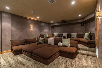 theatre room with large plush couches and lounging area